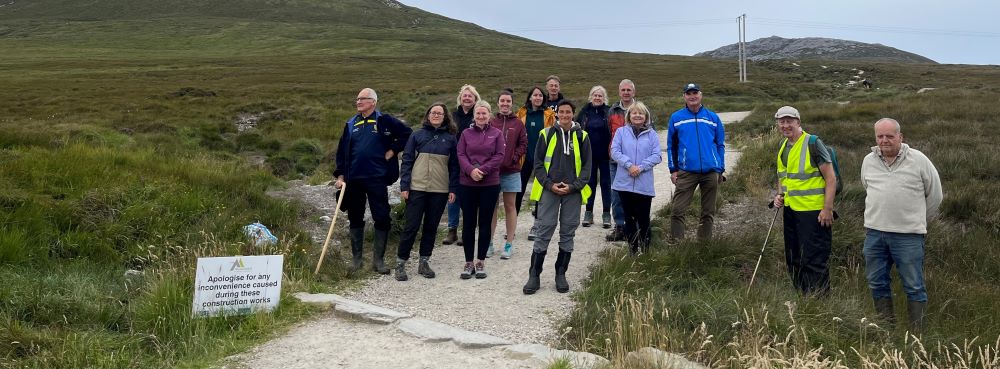 A group of people in hiking together posing together for a photograph on a walking path at Mount Errigal, Donegal